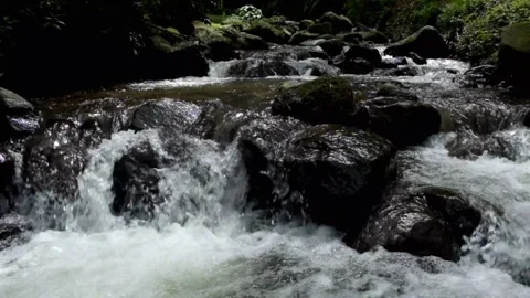 The movement of water falling through a rocky river cascade Stock Footage 297650849