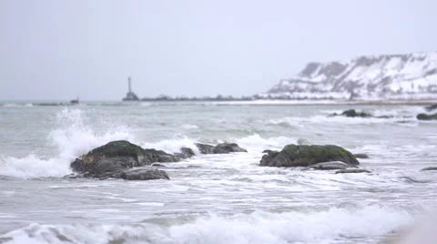 The movement of the waves on the shore with a view of the lighthouse. Seascape. Stock Footage 53079842
