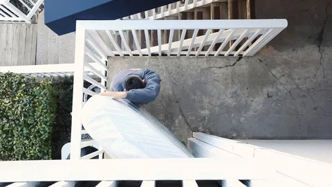 Movers carry a mattress outside Stock Footage 124767965