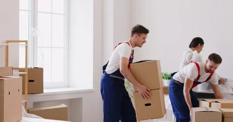 Movers Helping Client Carry Cardboard Boxes During Home Or Office Relocation Stock Footage 268026955