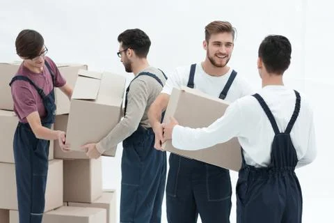 Movers lifting stack of cardboard moving boxes isolated on white Stock Photos