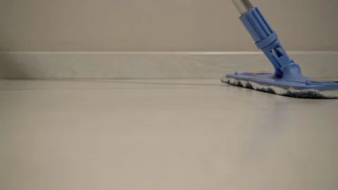 Moves the floor along the wall with a mop 库存影片 142907441