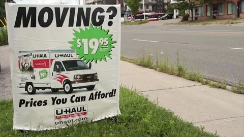 Moving 1995 20 dollars prices you can afford uhaul sign on grass with logo Stock Footage 248714786