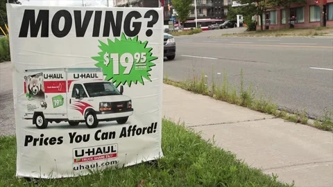 Moving 1995 20 dollars prices you can afford uhaul sign on grass with logo Stock Footage 248714810