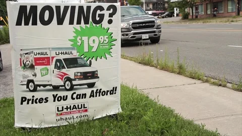 Moving 1995 20 dollars prices you can afford uhaul sign on grass with logo Stock Footage 248714848