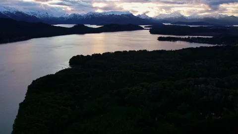 Moving aerial hyperlapse of Nahuel Huapi Lake with sunset reflections and snowy Video stock 334178239