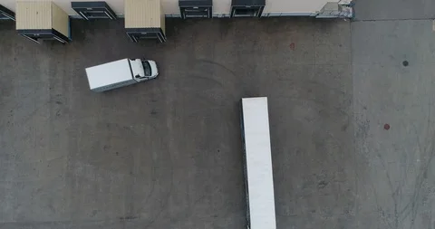Moving aerial side shot many truck with semi trailers load unload merchandise Stock Footage 107144374