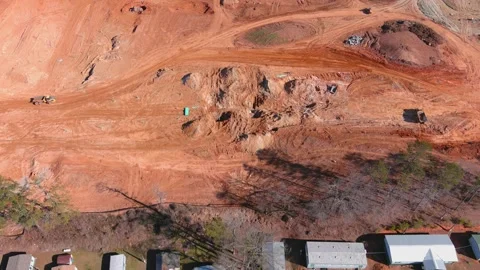 Moving aerial view of construction site near homes and dump truck moving Stock Footage 177074817
