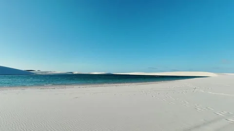 Moving Along a Lagoon Between White Dunes in Lençóis Maranhenses Video stock 342443974