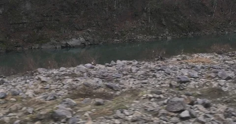 Moving along mountain river with rocks. Traveling by train in Japan highlands Video stock 123825805