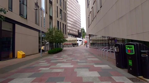 Moving along a paved walkway between two modern buildings Video stock 200262156