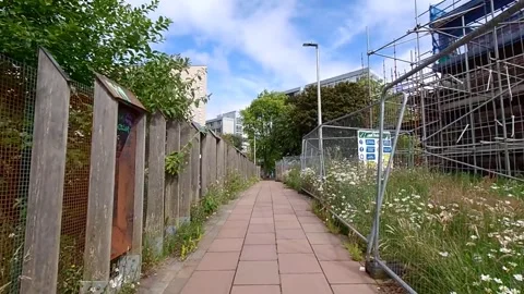 Moving along a paved walkway with a construction site on one side Video stock 200262052
