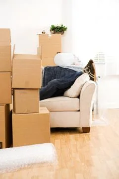Moving: Anonymous Man Resting On Couch After Packing Stock Photos