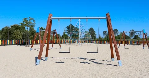 Moving away double empty swings in playground Stock Footage 101471524