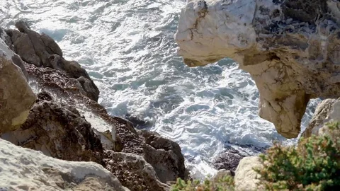 Moving backward from above the ocean waves between rocks. Stock Footage 127426940
