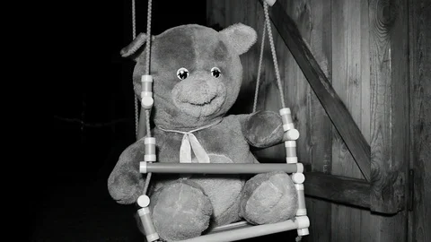 Moving beam of light gradually illuminates the teddy bear, black and white Stock Footage 120247056