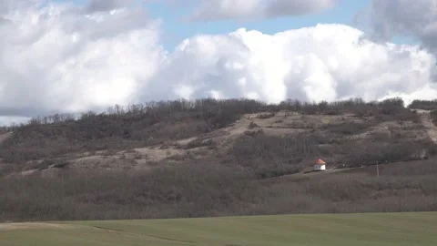 Moving beautiful clouds over a field, small chapel in the background Stock Footage 150707803