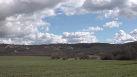 Moving beautiful clouds over a field, small chapel in the background Stock Footage 151358121