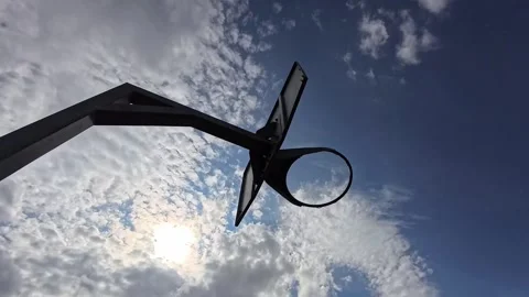 Moving below basketball hoop under sunny blue cloudy sky rotation Video stock 343561774
