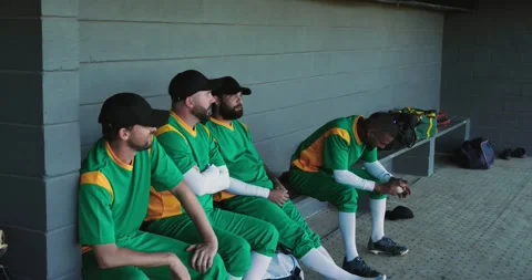 Moving to bench, standing player prompting male teammates tapping baseball Stock Footage 336241842