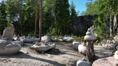Moving between balanced pebble pyramids at the entrance to the Temple of Stock Footage 265180265
