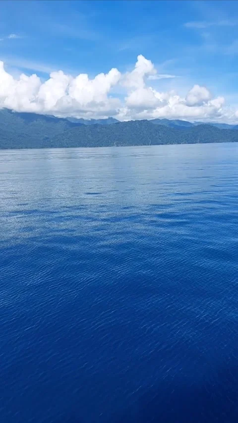 Moving boat perspective toward lush mountains and dramatic clouds. Stock Footage 346215369