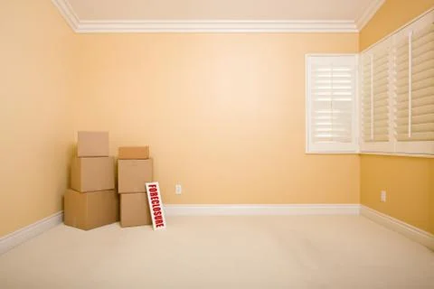 Moving Boxes and Foreclosure Real Estate Sign on Floor in Empty Room Stock Photos