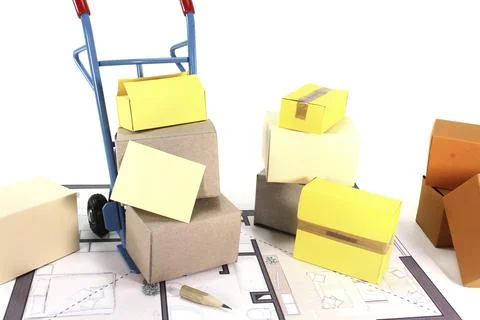 Moving boxes with hand truck, notepad and floor plan Foto stock