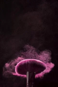 Moving brush cloud makeup powder black background Stock Photos