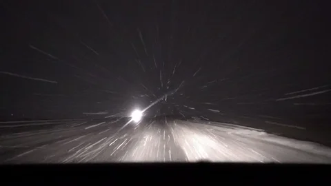 Moving car headlight in night road with snow and strong blizzard Stock Footage 100897490