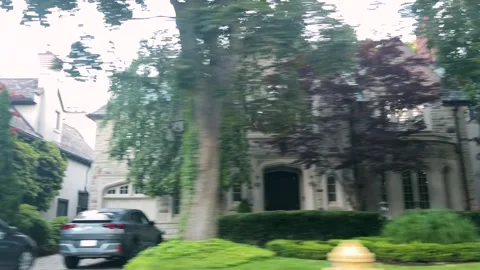  A moving car perspective shot reveals a luxury mansion. Video stock 343676253