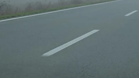 Moving car POV showing dashed road lines blurred by motion, creating a dynamic Stock Footage 321704781