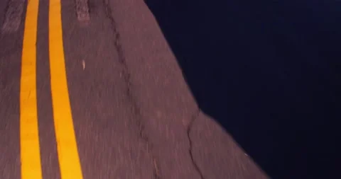 Moving car shadow on empty winding road Stock Footage 136340932