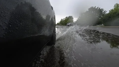 Moving car tire splashing through deep water during heavy rain. Dramatic view 스톡 동영상 344028508
