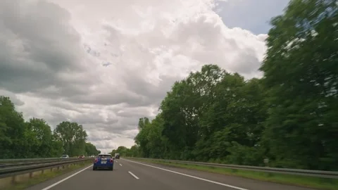 Moving-car view of traffic on a German autobahn beneath a dramatic cloudy sky. Видео 338032492
