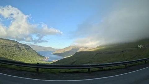 Moving car window view of a coastal fjord port and rolling fog under blue sky Stock Footage 339096810