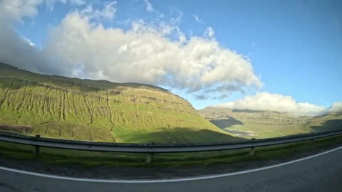Moving car window view of a road trip through green hills under blue sky Stock Footage 339096805
