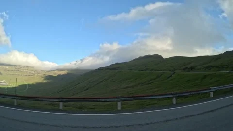 Moving car window view of a sharp turn on a coastal mountain pass under blue sky Stock Footage 339096808