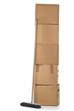 Moving carton boxes stack with broom Stockfoto's