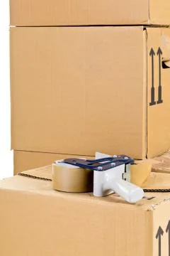 Moving carton boxes stack with tape roller Stock Photos