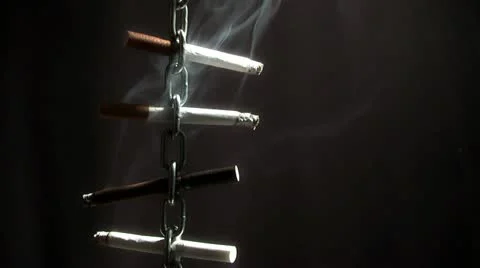 Moving chain with a cigarette on a black background Stock Footage 12152660
