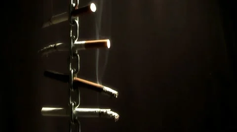 Moving chain with a cigarette on a black background Stock Footage 12152667