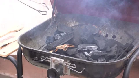 Moving the charcoal on a grill Stock Footage 143349230