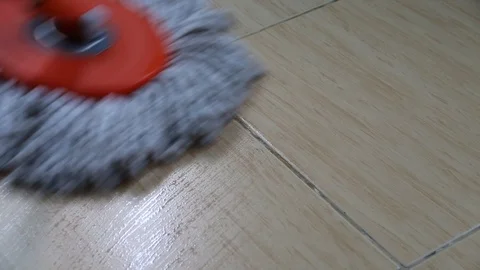 A moving cloth mop is used to clean a tile floor. Stock Footage 105899134