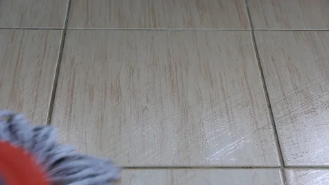 A moving cloth mop is used to clean a tile floor. Stock Footage 105942354