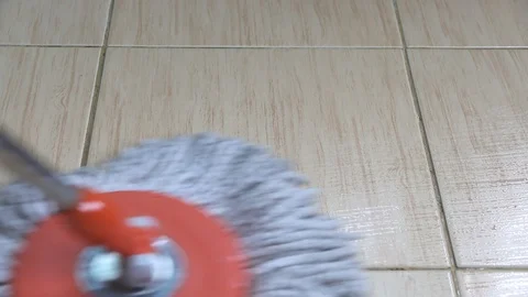 A moving cloth mop is used to clean a tile floor. Stock Footage 105942593