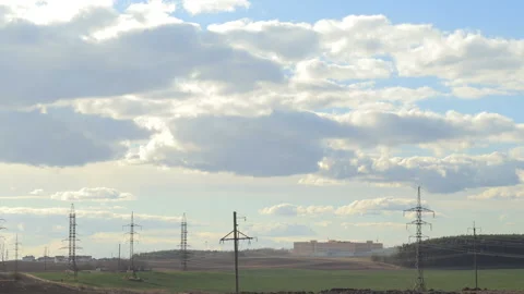 Moving clouds above the meadow with electric wires near the city Stock Footage 89691955