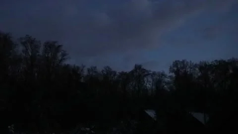 Moving clouds and darkening over the trees on the edge of forest - timelaps Stock Footage 232325435