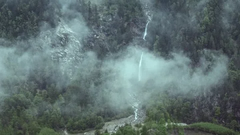 Moving clouds on the background of a slope of mountains with waterfall Stock Footage 310640302