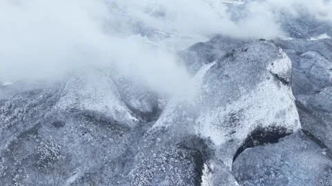 Moving Clouds Cover a Snowy Mountain Peak in a Static Aerial View Stock Footage 344248136